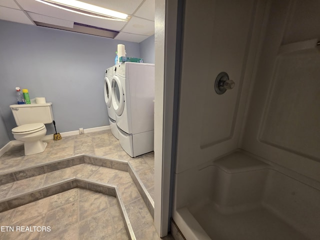 full bath featuring baseboards, a walk in shower, independent washer and dryer, and toilet