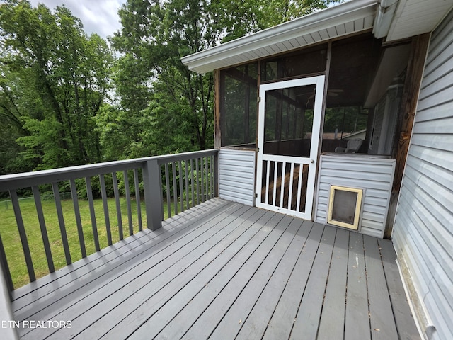 deck with a lawn and a sunroom