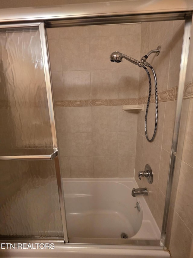 bathroom with shower / bath combination with glass door