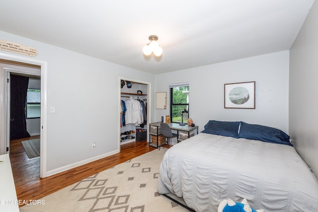 bedroom featuring wood finished floors, a closet, and baseboards