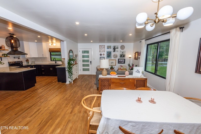 dining area featuring a chandelier, light wood-style floors, and recessed lighting
