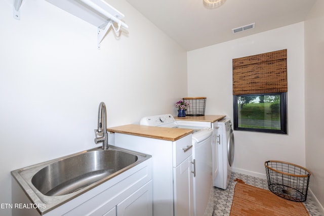 washroom with washer and clothes dryer, cabinet space, and baseboards