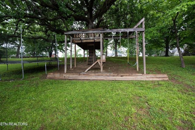 communal playground featuring a trampoline and a yard