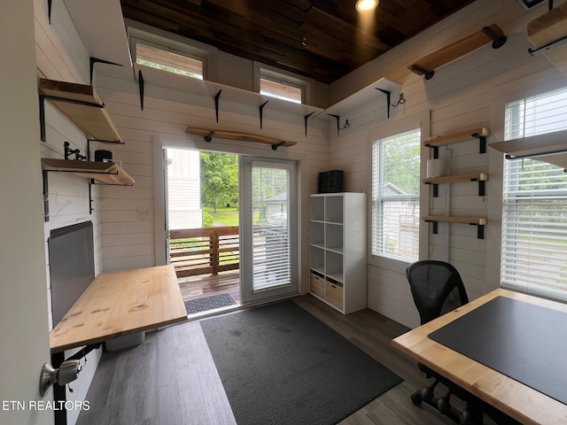 office featuring wood walls, wood finished floors, a high ceiling, and wooden ceiling