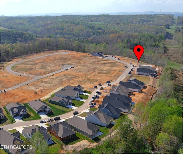 aerial view featuring a residential view and a wooded view