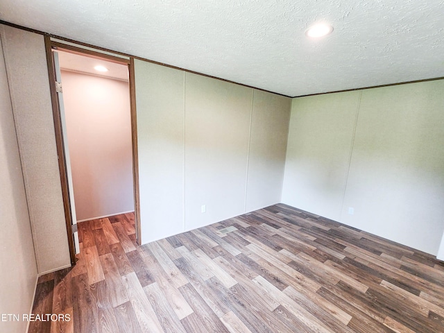 spare room featuring recessed lighting, a textured ceiling, and wood finished floors