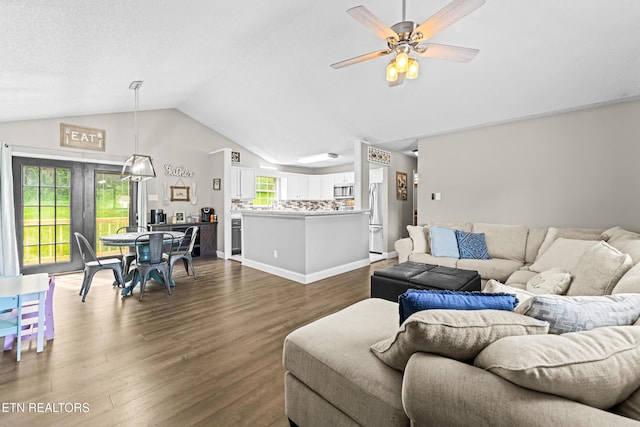 living area with lofted ceiling, ceiling fan, and dark wood finished floors