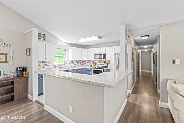 kitchen with tasteful backsplash, blue cabinets, stainless steel appliances, and light wood-style floors