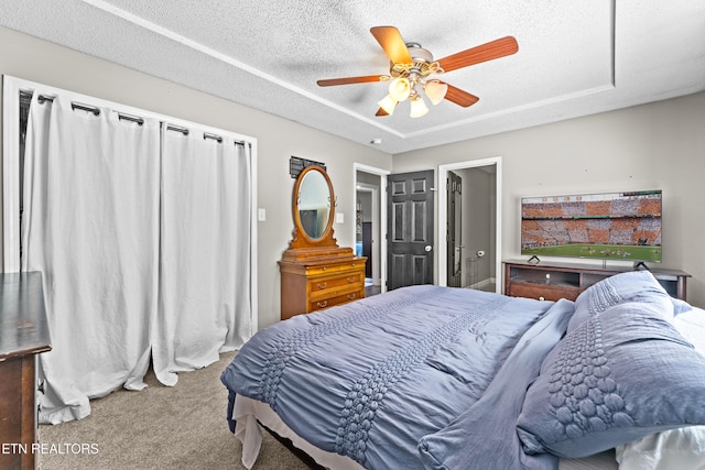 carpeted bedroom with a textured ceiling and a ceiling fan