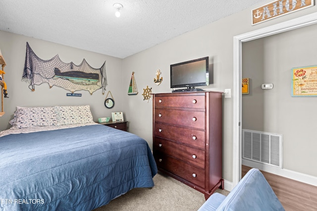 bedroom featuring a textured ceiling and visible vents