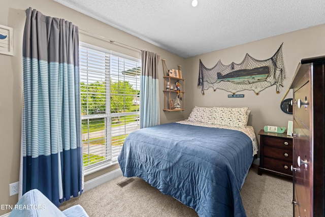 carpeted bedroom with a textured ceiling and baseboards