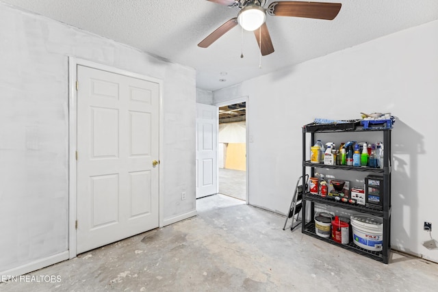 interior space with a textured ceiling, ceiling fan, and unfinished concrete flooring