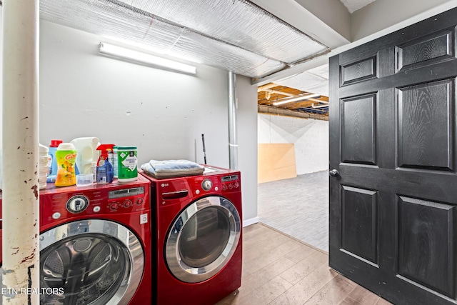 clothes washing area with wood finished floors, washer and clothes dryer, and laundry area