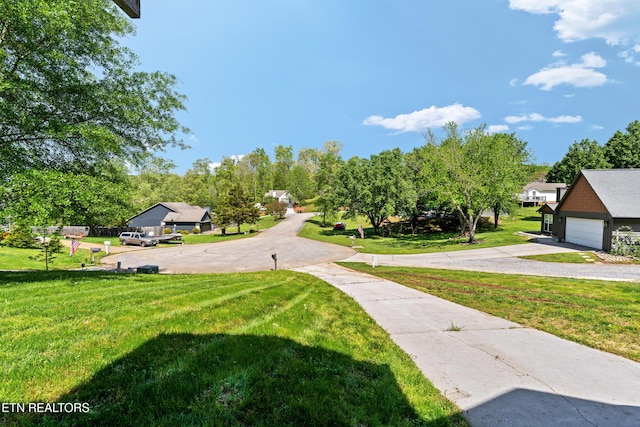 view of home's community featuring a garage, driveway, and a lawn