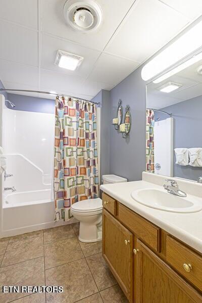 bathroom with tile patterned floors, shower / bath combination with curtain, toilet, and vanity