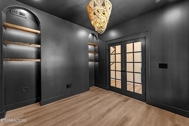 922 Eagle Point Dr, Loudon, TN 37774 - empty room with visible vents, french doors, a chandelier, and wood finished floors