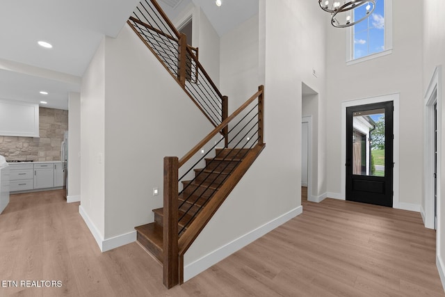 922 Eagle Point Dr, Loudon, TN 37774 - entrance foyer featuring stairs, a notable chandelier, light wood-style flooring, and a high ceiling