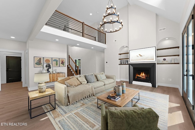 922 Eagle Point Dr, Loudon, TN 37774 - living area with a lit fireplace, high vaulted ceiling, visible vents, and wood finished floors
