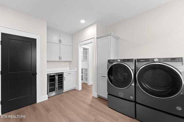 922 Eagle Point Dr, Loudon, TN 37774 - clothes washing area featuring cabinet space, wine cooler, light wood-type flooring, washer and dryer, and bar area