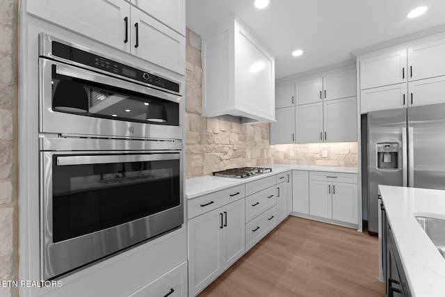 922 Eagle Point Dr, Loudon, TN 37774 - kitchen with stainless steel appliances, recessed lighting, decorative backsplash, white cabinets, and light wood-style floors