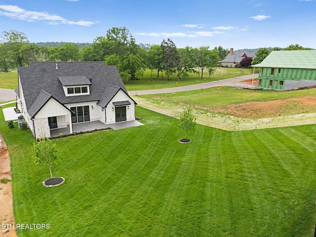 922 Eagle Point Dr, Loudon, TN 37774 - exterior space featuring a lawn, a shingled roof, a patio, and board and batten siding