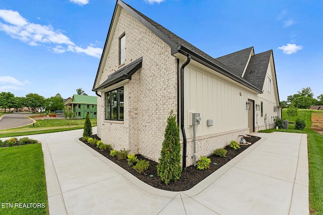 922 Eagle Point Dr, Loudon, TN 37774 - view of home's exterior with a shingled roof, board and batten siding, brick siding, and a yard