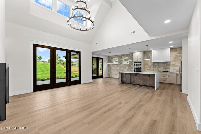 922 Eagle Point Dr, Loudon, TN 37774 - kitchen featuring light wood finished floors, an inviting chandelier, high vaulted ceiling, open floor plan, and light countertops