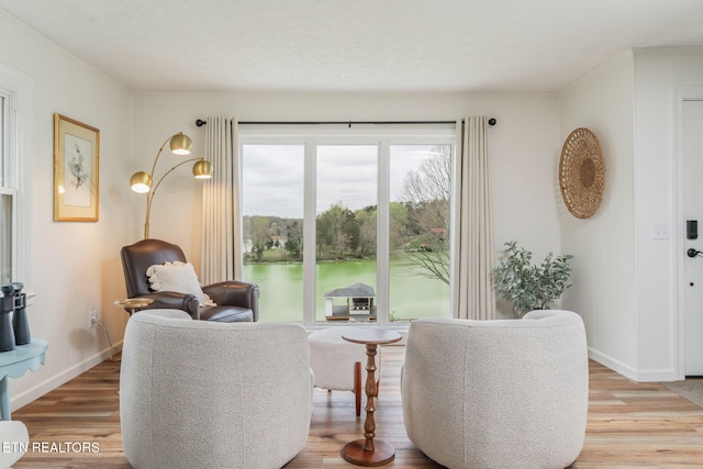 sitting room with baseboards and light wood finished floors