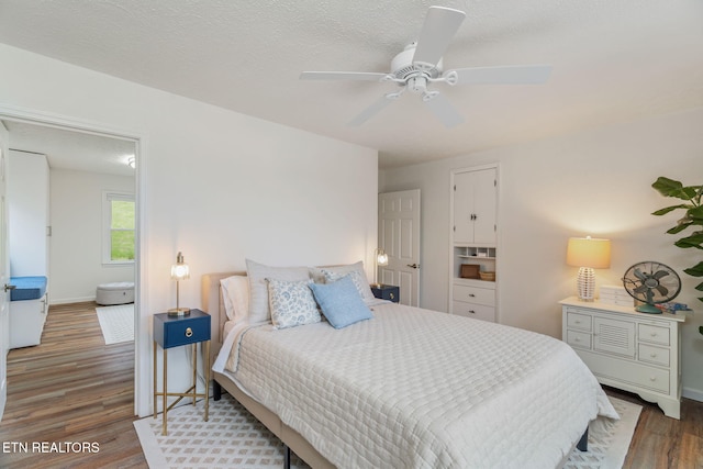 bedroom featuring wood finished floors, ceiling fan, and baseboards