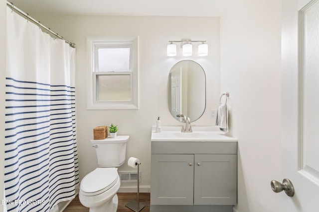 full bathroom featuring visible vents, baseboards, toilet, wood finished floors, and vanity