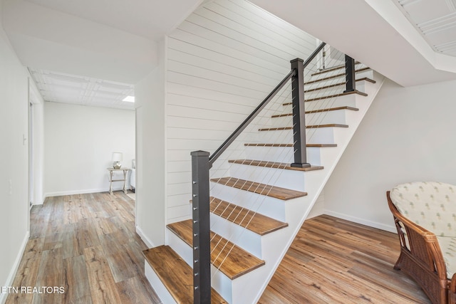 stairs with wood finished floors and baseboards