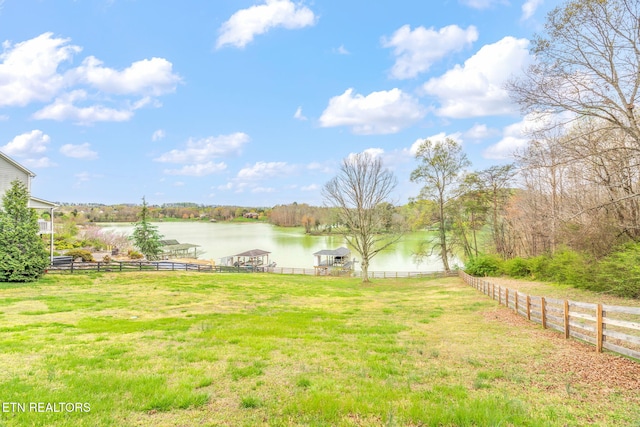 view of yard featuring a water view and fence