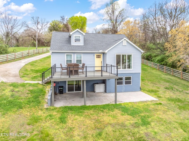 back of property with a lawn, fence, a patio, and a wooden deck