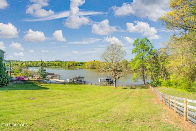 view of yard featuring a water view and fence