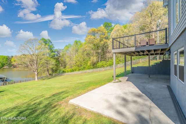 view of yard featuring a deck with water view, a fenced backyard, and a patio area