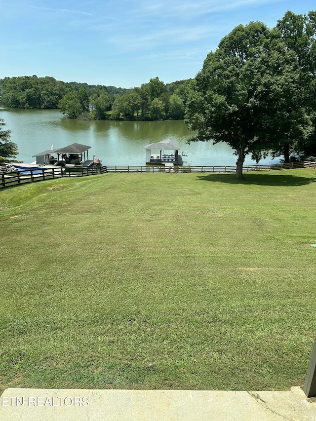 view of yard with fence and a water view