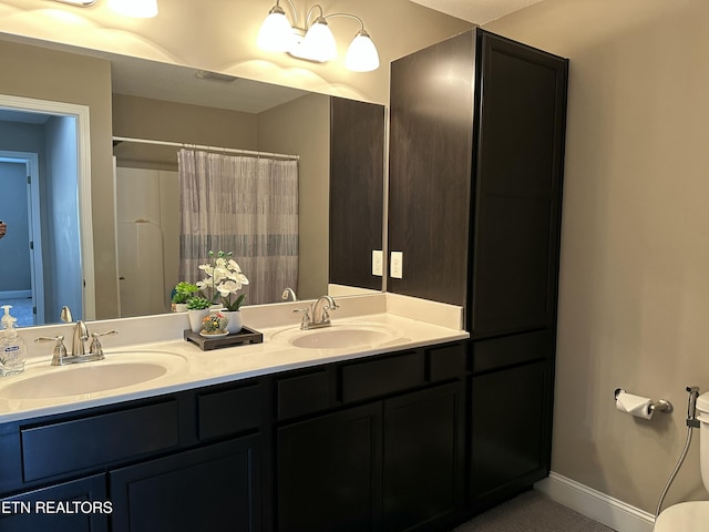 1631 Silver Spur Ln, Knoxville, TN 37932 - bathroom featuring double vanity, baseboards, a shower with shower curtain, and a sink