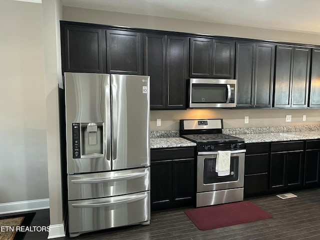 1631 Silver Spur Ln, Knoxville, TN 37932 - kitchen with dark wood-style floors, stainless steel appliances, dark cabinets, and light stone counters