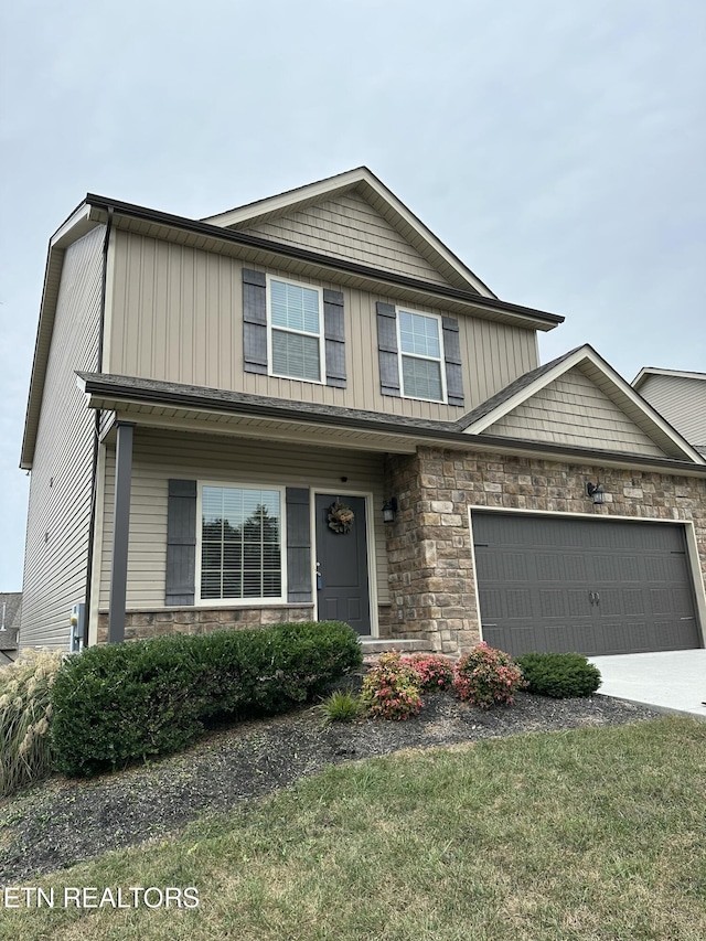1631 Silver Spur Ln, Knoxville, TN 37932 - view of front of home featuring a front yard, a garage, driveway, stone siding, and board and batten siding