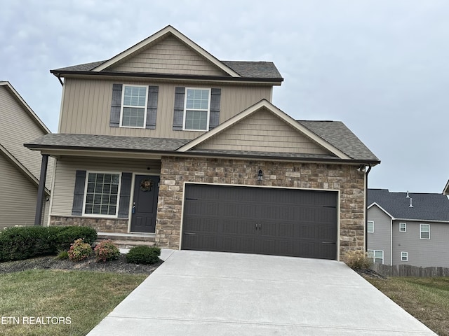 1631 Silver Spur Ln, Knoxville, TN 37932 - craftsman house featuring concrete driveway, stone siding, a front lawn, and covered porch