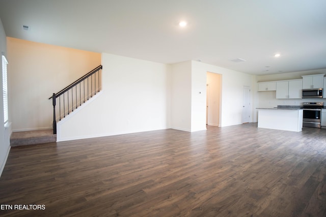 unfurnished living room with stairway, recessed lighting, baseboards, and dark wood finished floors