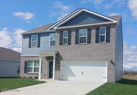 craftsman house featuring an attached garage, driveway, and brick siding