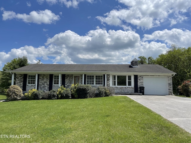 view of front of property featuring an attached garage, concrete driveway, and a front lawn