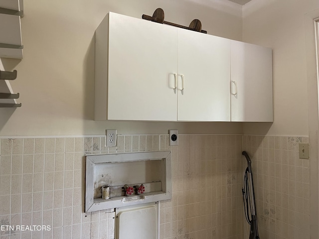 laundry room with a wainscoted wall, tile walls, and laundry area