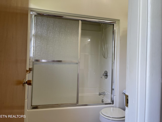 full bath featuring toilet and shower / bath combination with glass door
