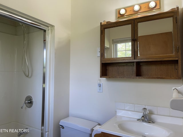 bathroom featuring a shower, vanity, and toilet