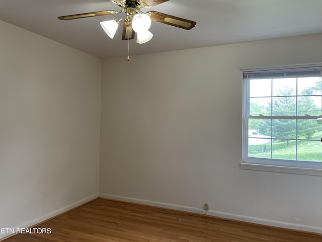 empty room with baseboards, a healthy amount of sunlight, and wood finished floors