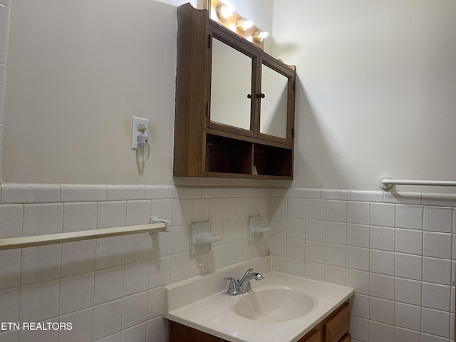 bathroom with tile walls, wainscoting, and vanity