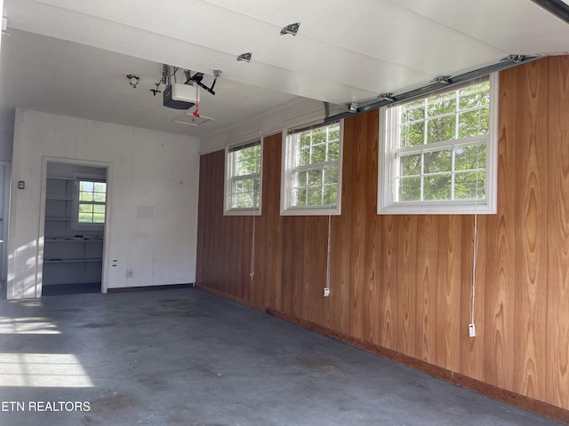 garage with wood walls and a garage door opener