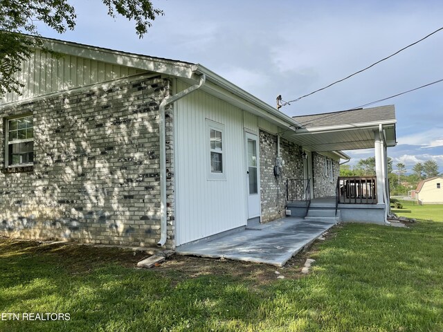 view of home's exterior featuring covered porch and a lawn